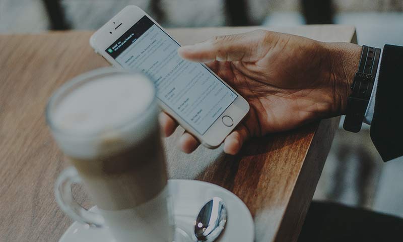 mobilt-mobigo Man med telefon och kaffe
